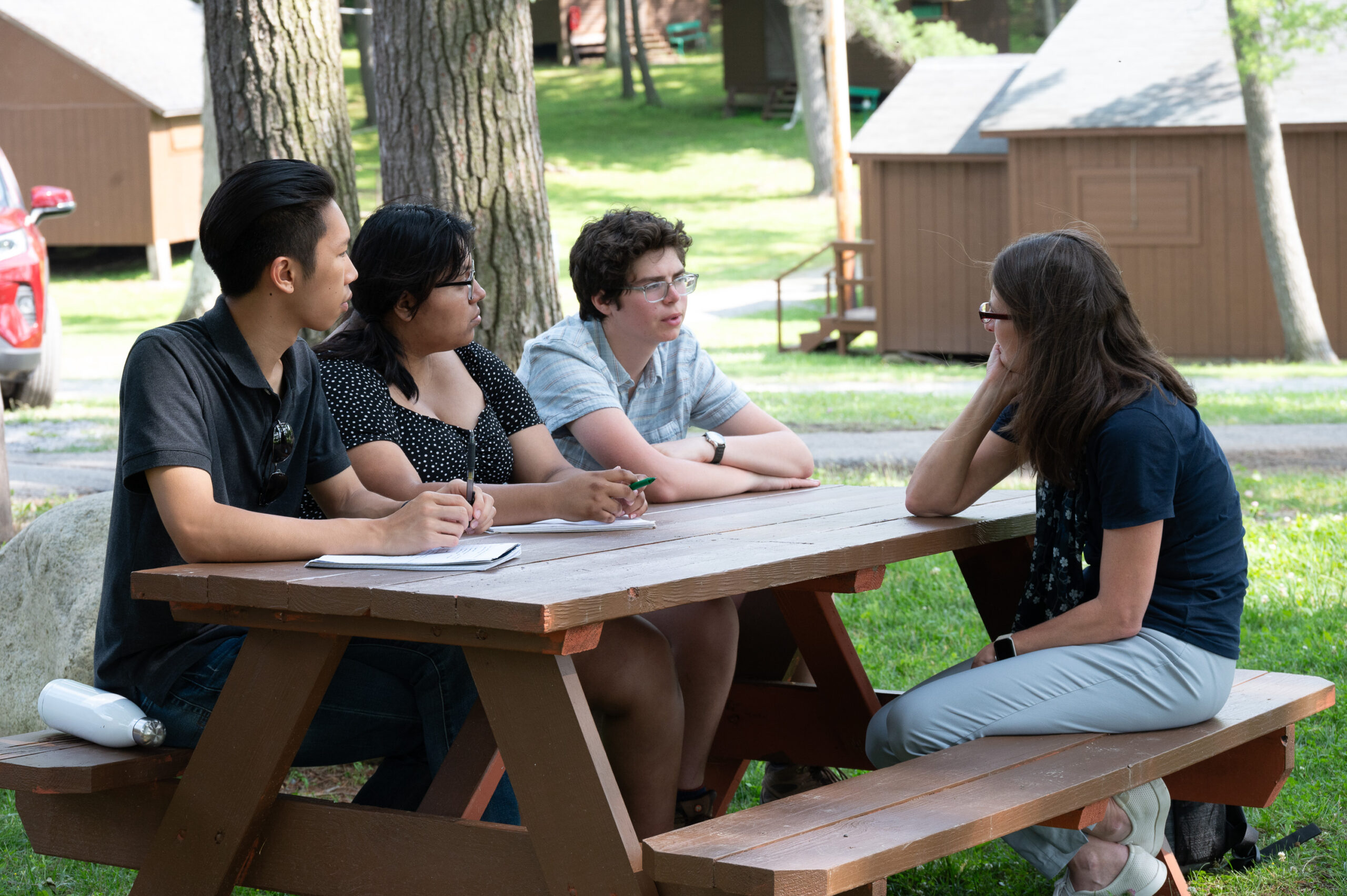 Student interns, from left, Russell Kwong, Sherla Zhagnay and Chet Lukanic speak with Sage Gerling, CCE Ontario County board member and associate director for business operations at the Cornell Agritech.