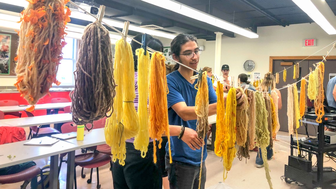 As part of the Earth Projects class, Sam Jurado ’24 hangs naturally dyed yarn to dry.