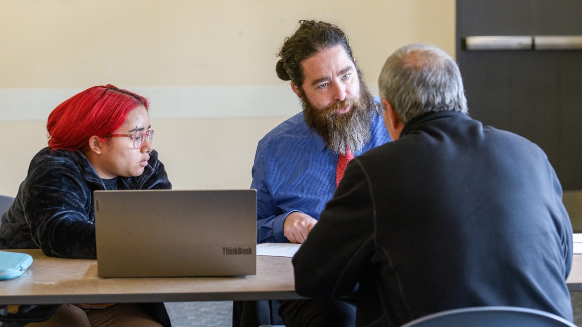 As part of the Pro Bono Legal Reentry Assistance program, Cornell Law School student Zaria Goicochea (left) and Jason Hoge (right), attorney from Legal Assistance of Western New York, work with a client at an Expungement Clinic at the Tompkins County Public Library on Oct. 23. 