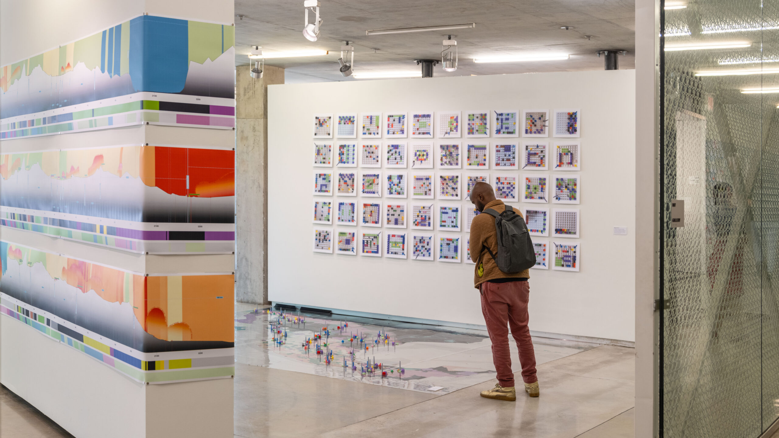 Person in the distance looking at art in a gallery