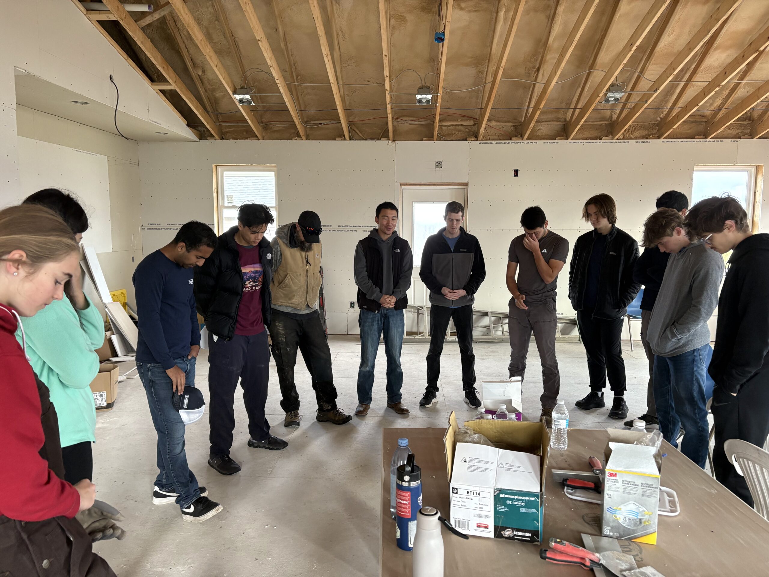 Frank Fang ’26 and students from CRU Cornell gathered in prayer at the Second Wind Cottages Community Center before a day of work. photo/provided