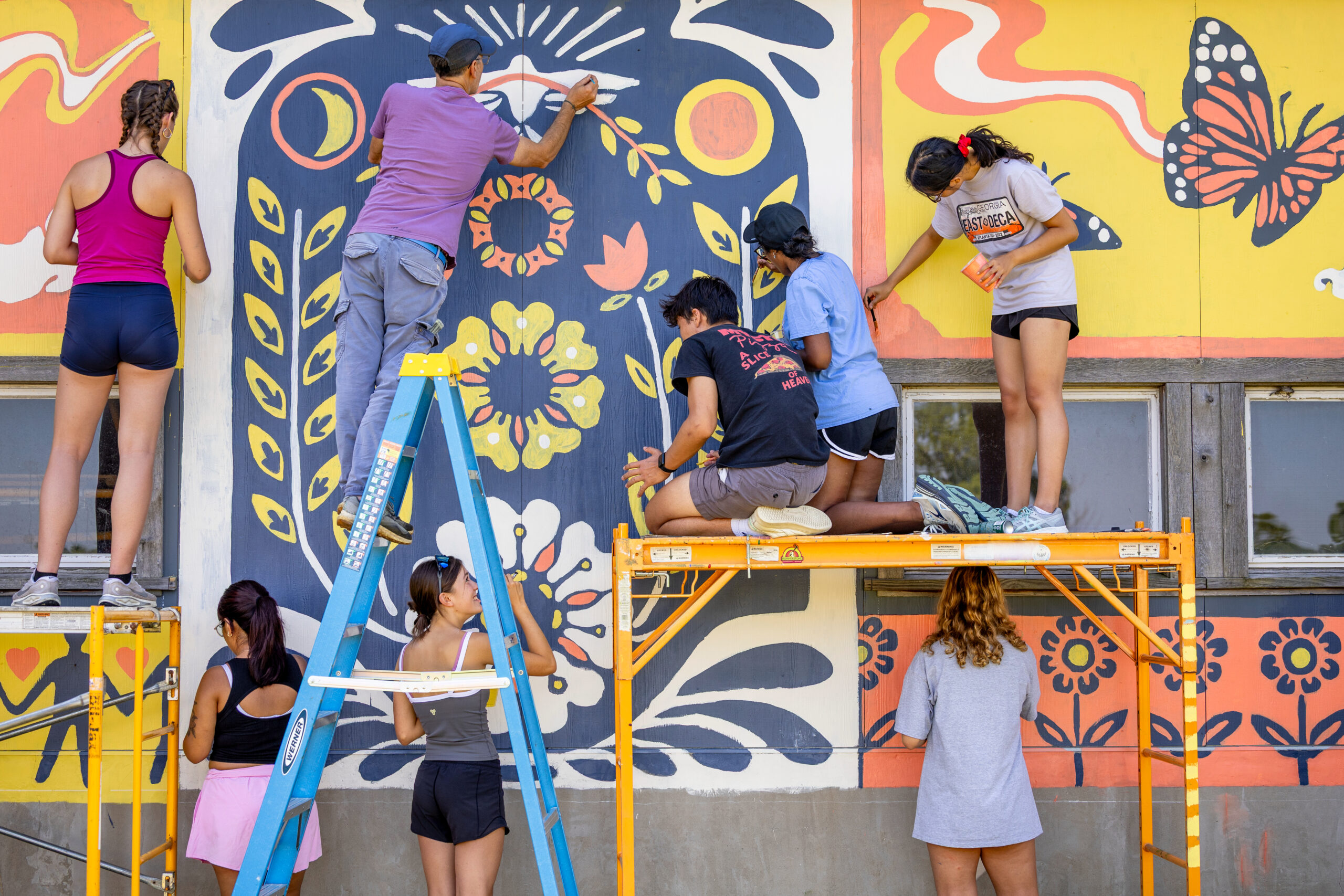 Students participate in a community paint event with local partner, Ithaca Murals, at Wildflower Farm in Enfield (Simon Wheeler for Cornell University)